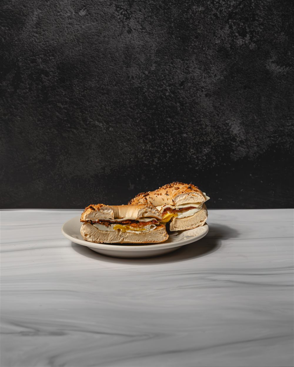 Bacon, egg and cheese sandwich on a toasted everything bagel, cut in half