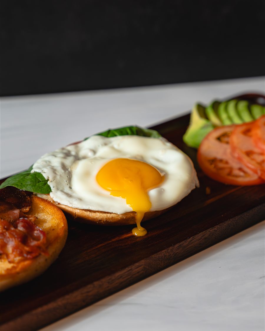 Bacon, a fried egg and avocado toast board
